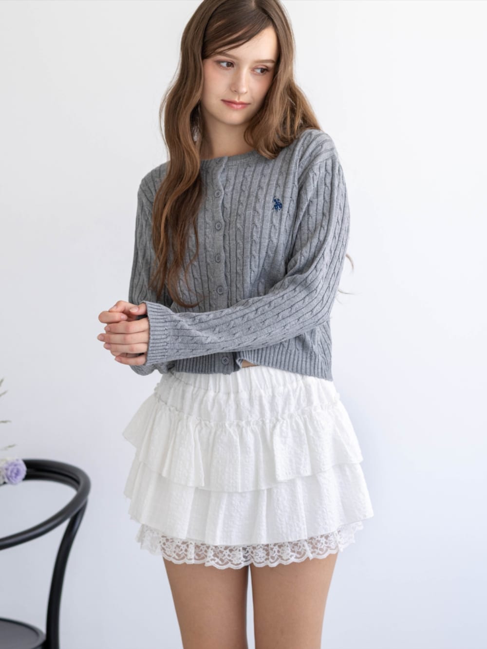 レッド系のパンプス、グレー系のカーディガン/ボレロ、ホワイト系のスカートを着用したレディースの秋コーディネートの6枚目の写真