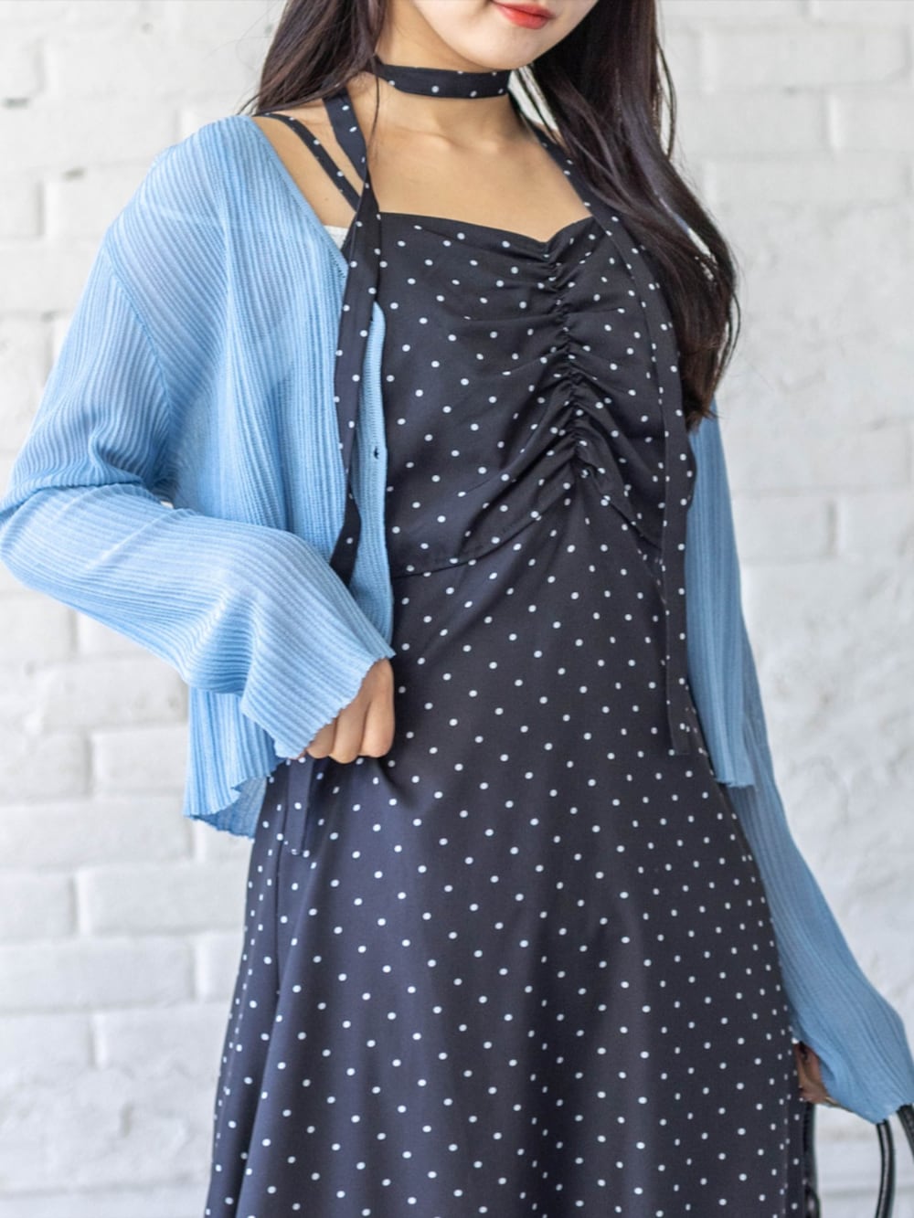 ブラック系のパンプス、グレー系のカーディガン/ボレロ、ブラック系のワンピースを着用したレディースの春コーディネートの3枚目の写真