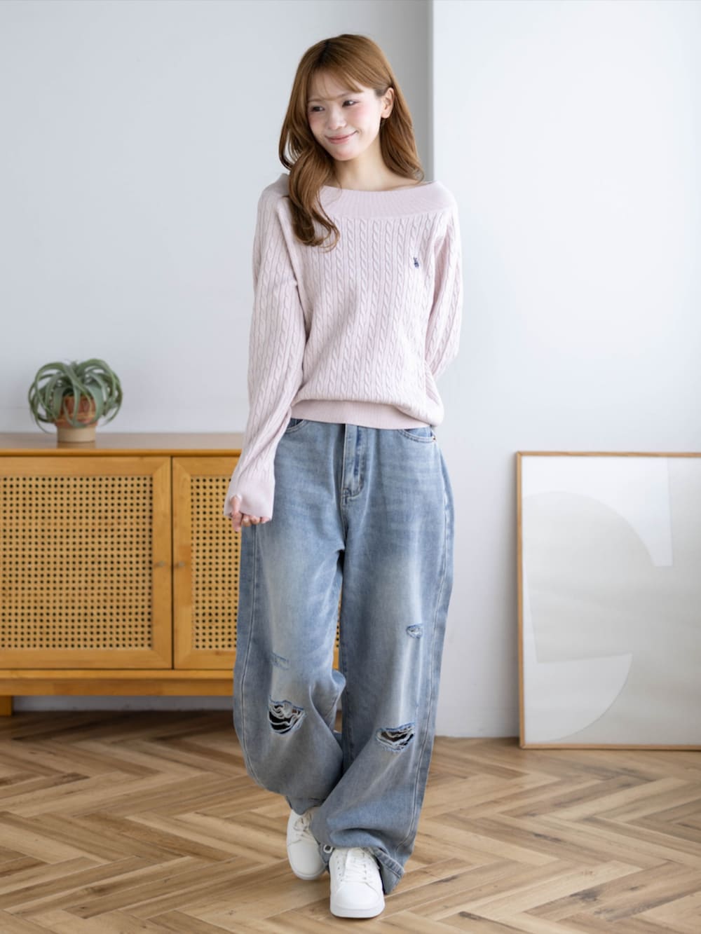 ピンク系のスニーカー、ブルー系のデニムパンツ、ピンク系のニット/セーターを着用したレディースの秋コーディネートの3枚目の写真