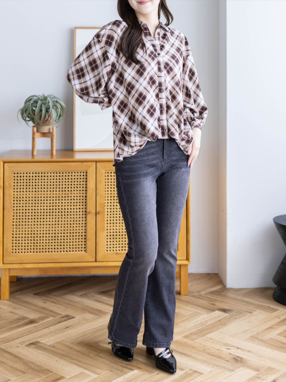ブラック系のデニムパンツ、ブラック系のパンプス、ブラウン系のシャツ/ブラウスを着用したレディースの夏コーディネートの2枚目の写真