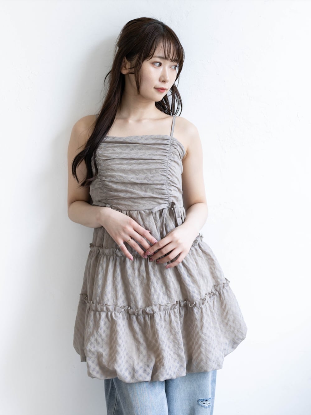 シルバー系のパンプス、ベージュ系のワンピース、ブルー系のデニムパンツを着用したレディースの夏コーディネートの6枚目の写真