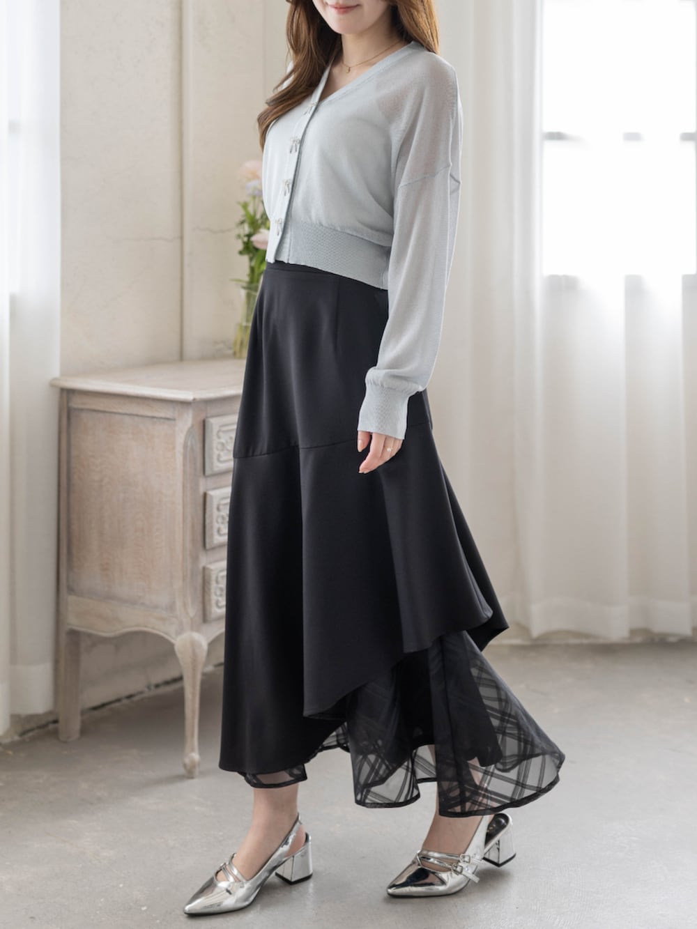 シルバー系のパンプス、ブラック系のスカート、グレー系のカーディガン/ボレロを着用したレディースの春コーディネートの3枚目の写真