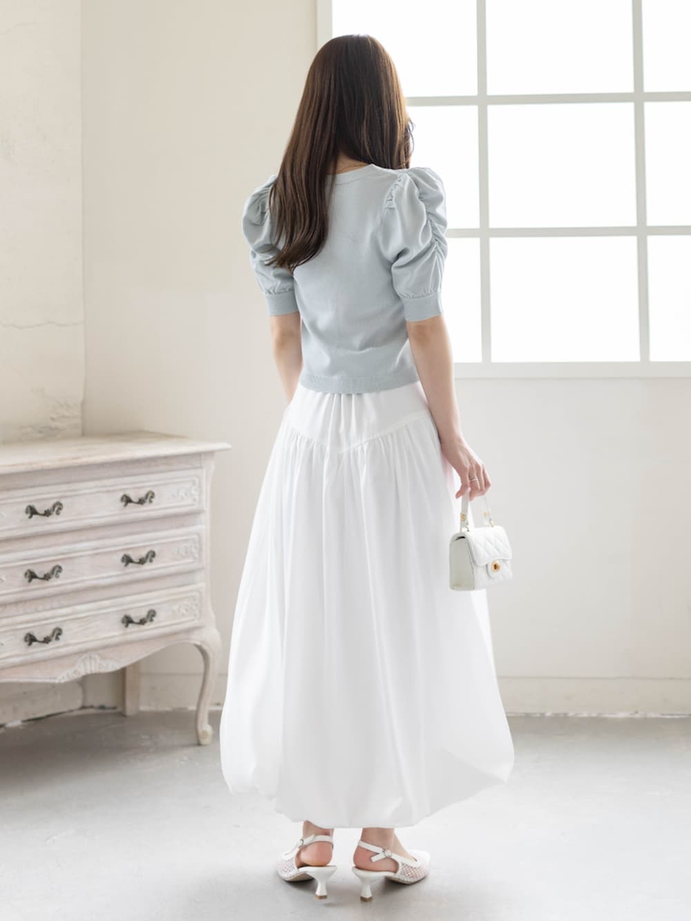 ホワイト系のスカート、ホワイト系のパンプス、グレー系のカーディガン/ボレロを着用したレディースの春コーディネートの4枚目の写真