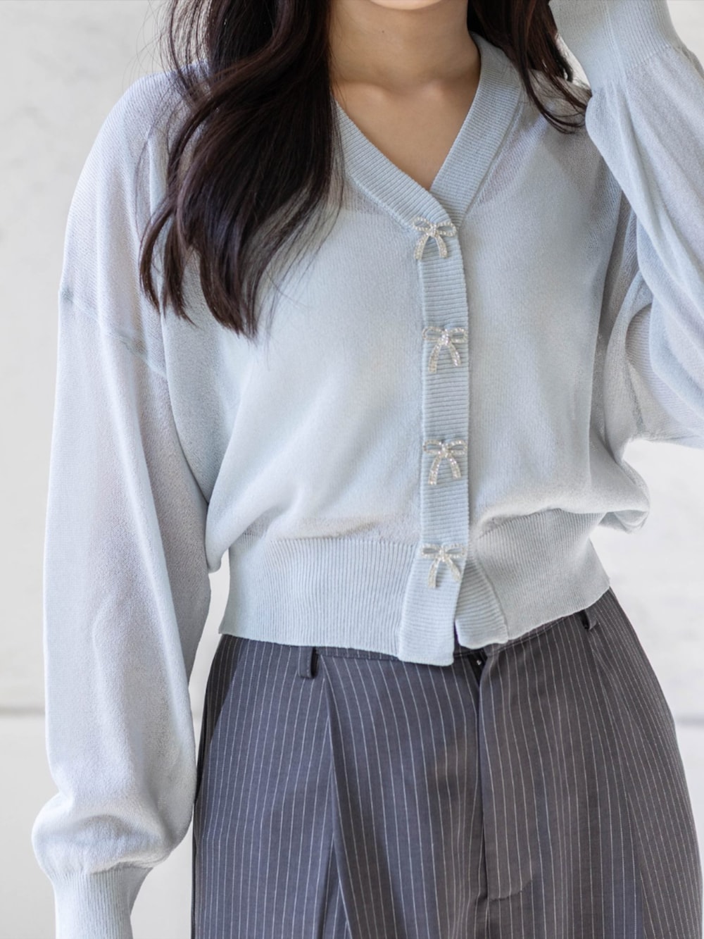 シルバー系のパンプス、グレー系のスラックス、グレー系のカーディガン/ボレロを着用したレディースの春コーディネートの5枚目の写真