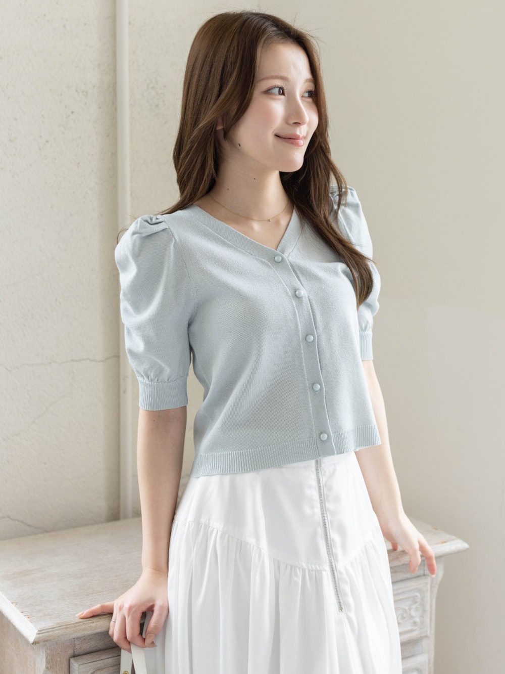 ホワイト系のスカート、ホワイト系のパンプス、グレー系のカーディガン/ボレロを着用したレディースの春コーディネートの8枚目の写真