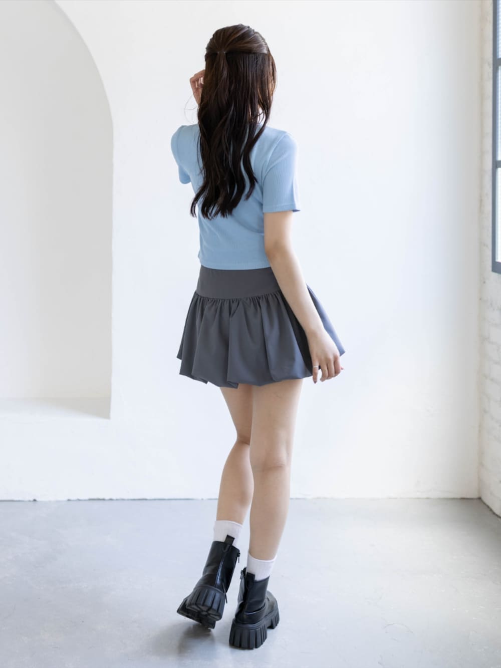 ブラック系のブーツ、グレー系のスカート、ブルー系のTシャツ/カットソーを着用したレディースの夏コーディネートの4枚目の写真