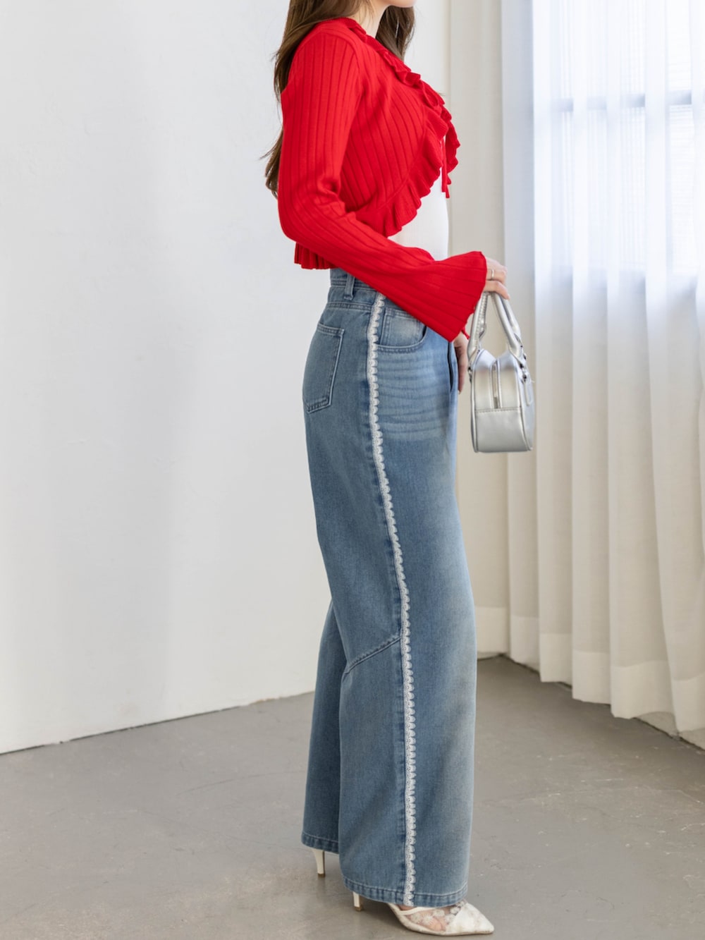 ブルー系のデニムパンツ、レッド系のカーディガン/ボレロを着用したレディースの冬コーディネートの3枚目の写真