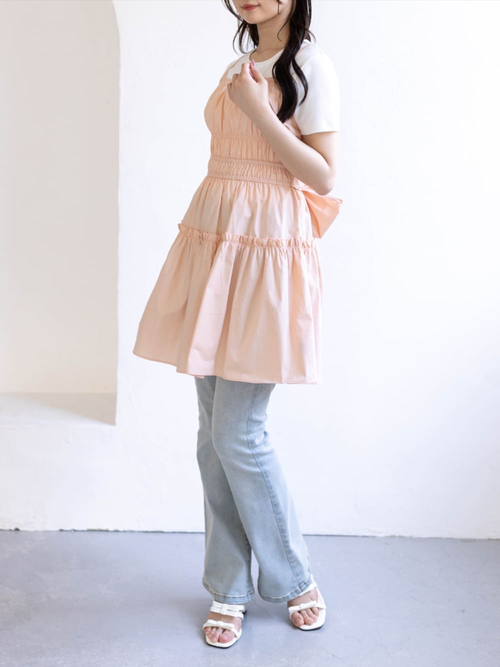 ブルー系のデニムパンツ、ホワイト系のサンダル、ピンク系のワンピースを着用したレディースの夏コーディネートの6枚目の写真