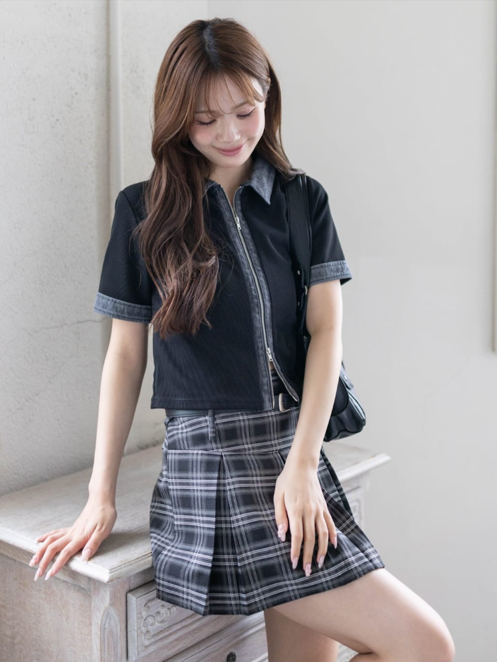 ブラック系のブーツ、ブラック系のTシャツ/カットソー、ブラック系のスカートを着用したレディースの春コーディネートの3枚目の写真