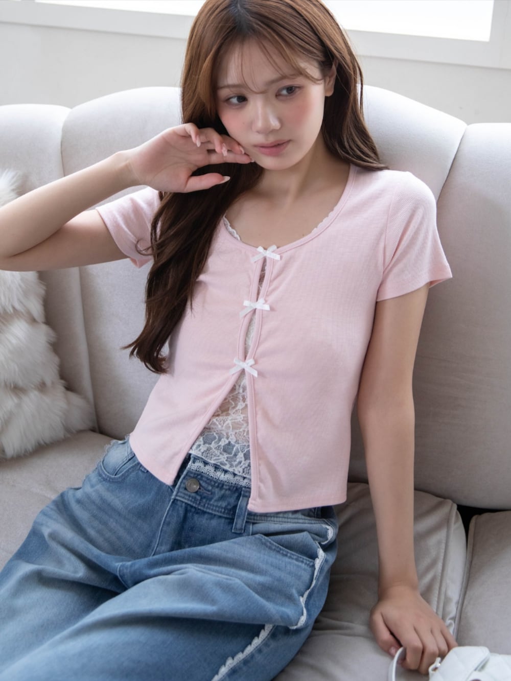 ブルー系のデニムパンツ、ピンク系のTシャツ/カットソー、ホワイト系のサンダルを着用したレディースの春コーディネートの4枚目の写真