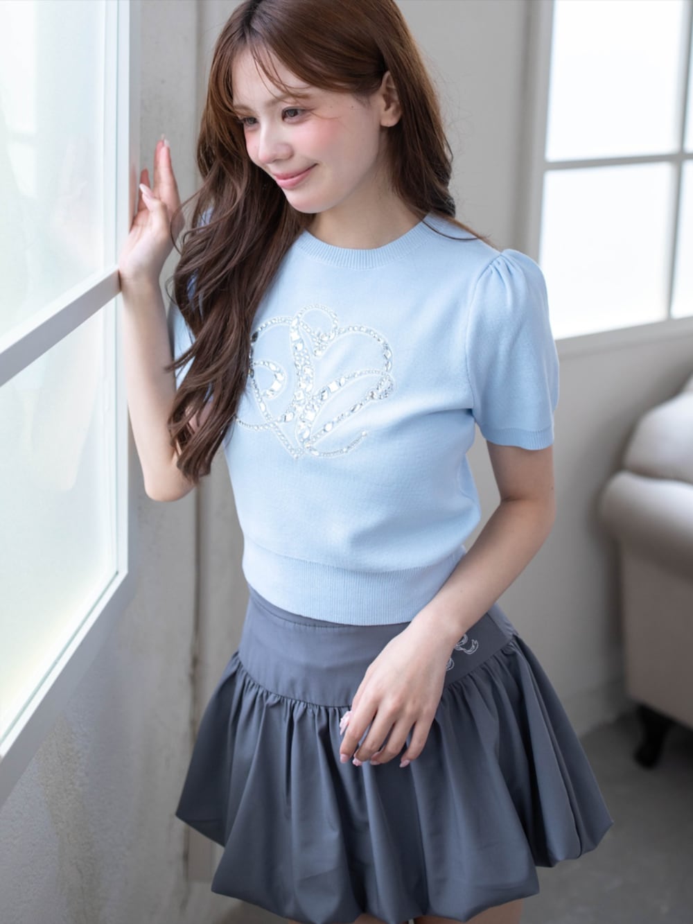 シルバー系のパンプス、ブルー系のニット/セーター、グレー系のスカートを着用したレディースの春コーディネートの4枚目の写真