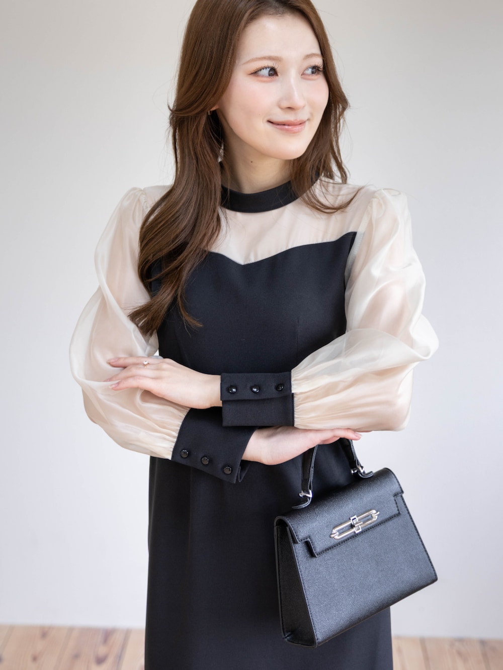 ブラック系のハンドバッグ、ブラック系のパンプス、ブラック系のワンピースを着用したレディースの春コーディネートの7枚目の写真