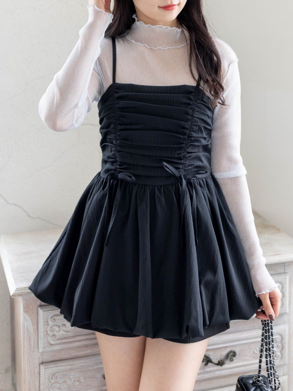 グレー系のTシャツ/カットソー、ブラック系のチュニック、ブラック系のパンプスを着用したレディースの春コーディネートの4枚目の写真