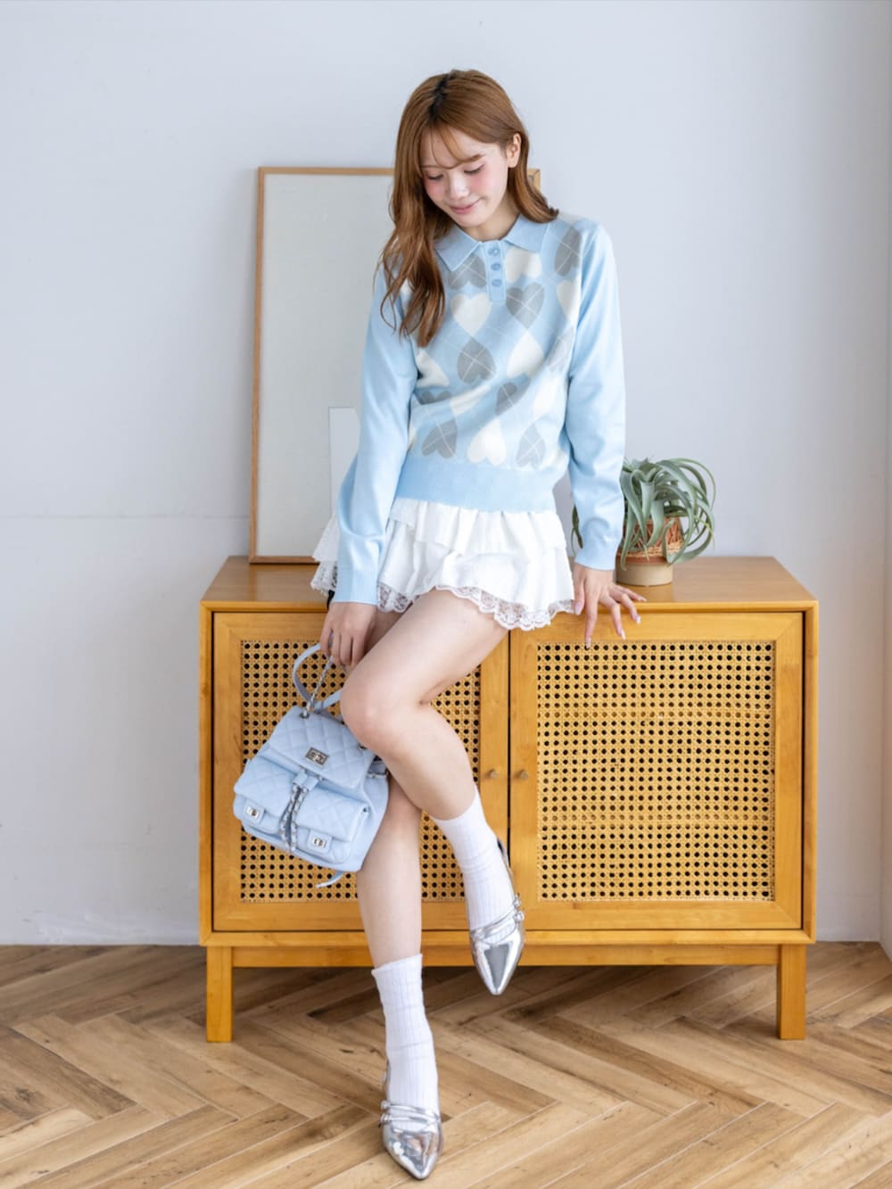 シルバー系のパンプス、ホワイト系のスカート、ブルー系のニット/セーターを着用したレディースの秋コーディネートの2枚目の写真