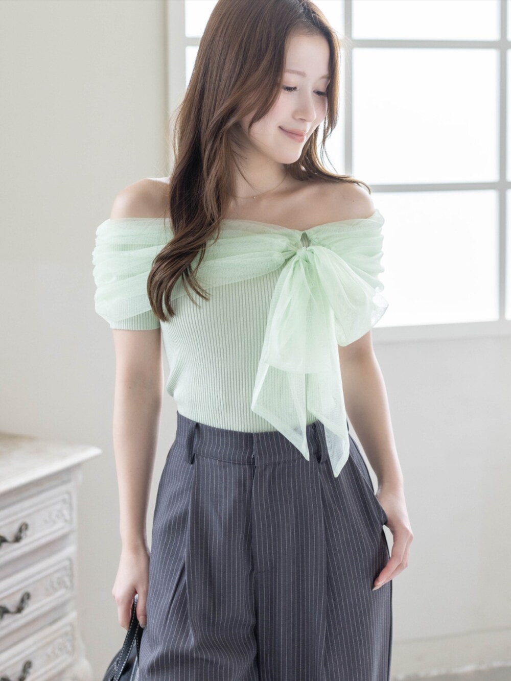 ブラック系のパンプス、グレー系のスラックス、グリーン系のニット/セーターを着用したレディースの夏コーディネートの7枚目の写真