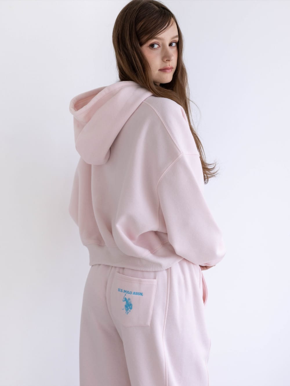 ピンク系のスニーカー、ピンク系のスウェットパンツ、ピンク系のパーカーを着用したレディースの秋コーディネートの8枚目の写真