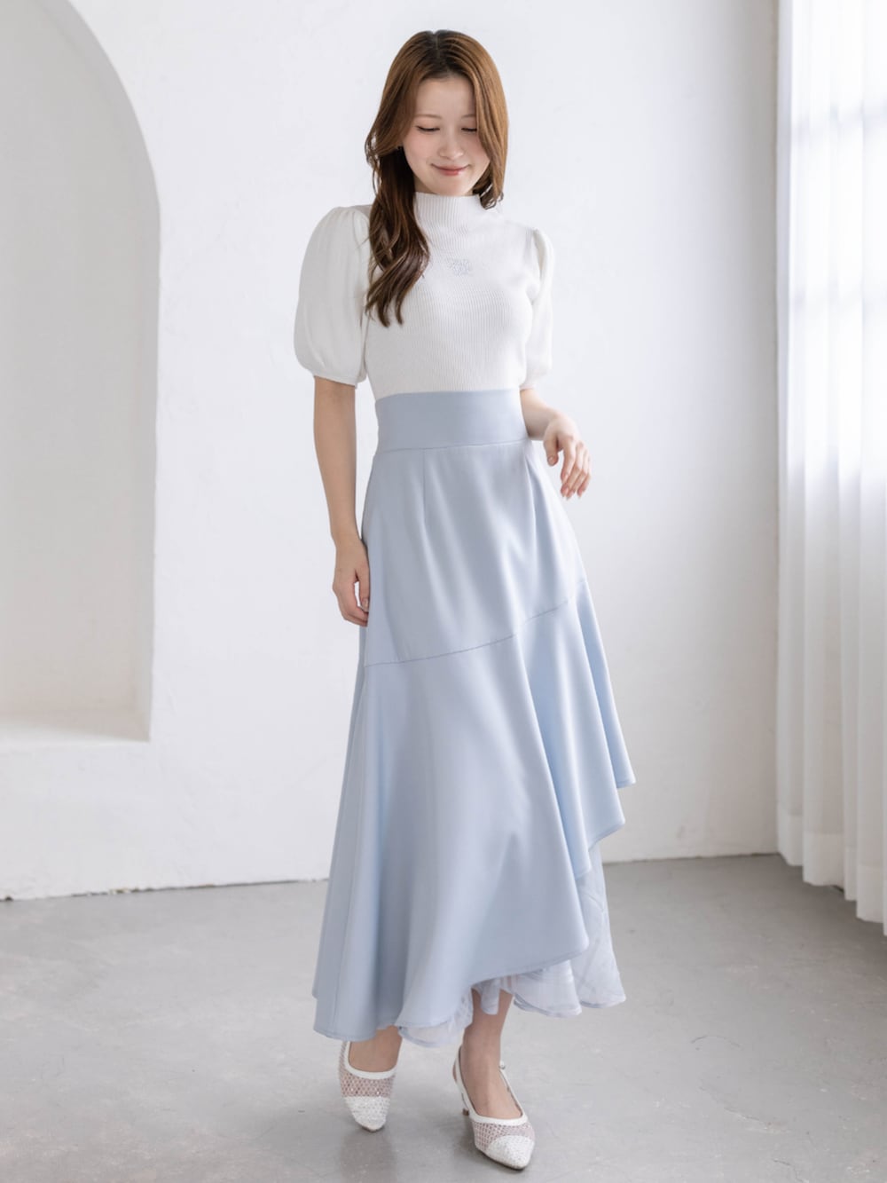 ホワイト系のパンプス、ブルー系のスカート、ホワイト系のニット/セーターを着用したレディースの春コーディネートの3枚目の写真