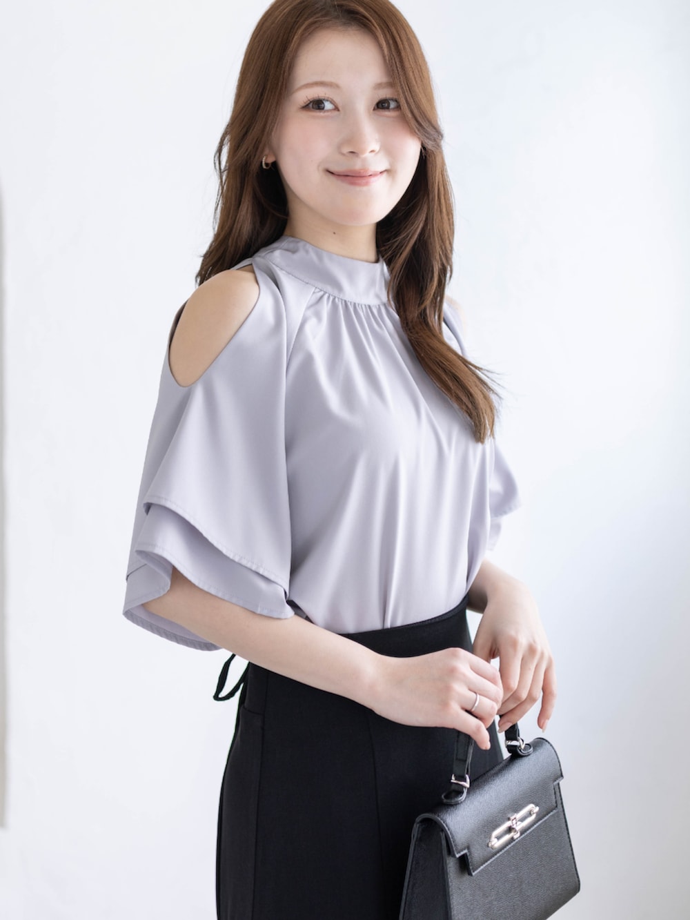 ブラック系のパンプス、グレー系のシャツ/ブラウス、ブラック系のハンドバッグを着用したレディースの春コーディネートの6枚目の写真