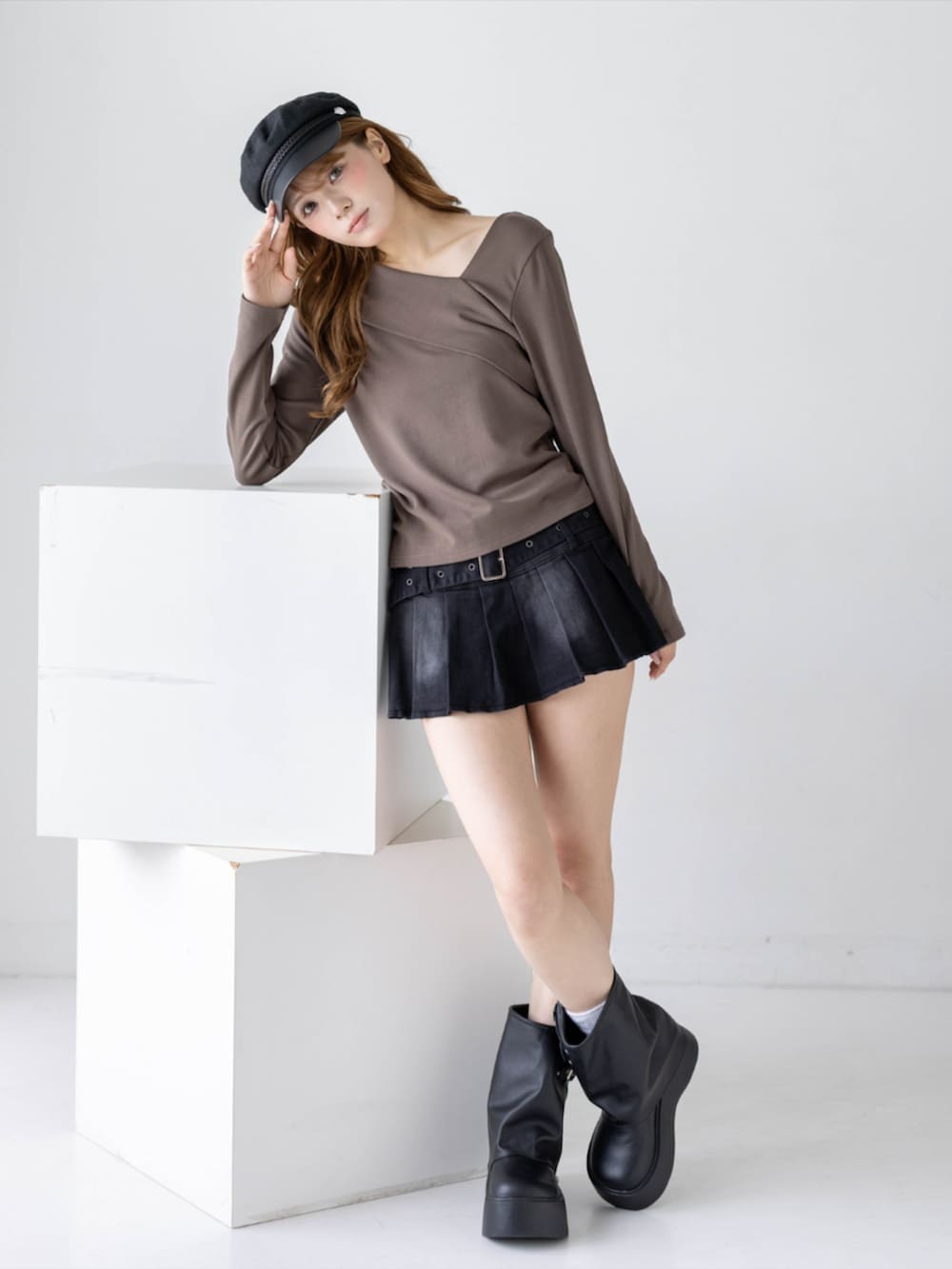 ブラック系のスカート、ブラック系のブーツ、ブラウン系のTシャツ/カットソーを着用したレディースの秋コーディネートの2枚目の写真