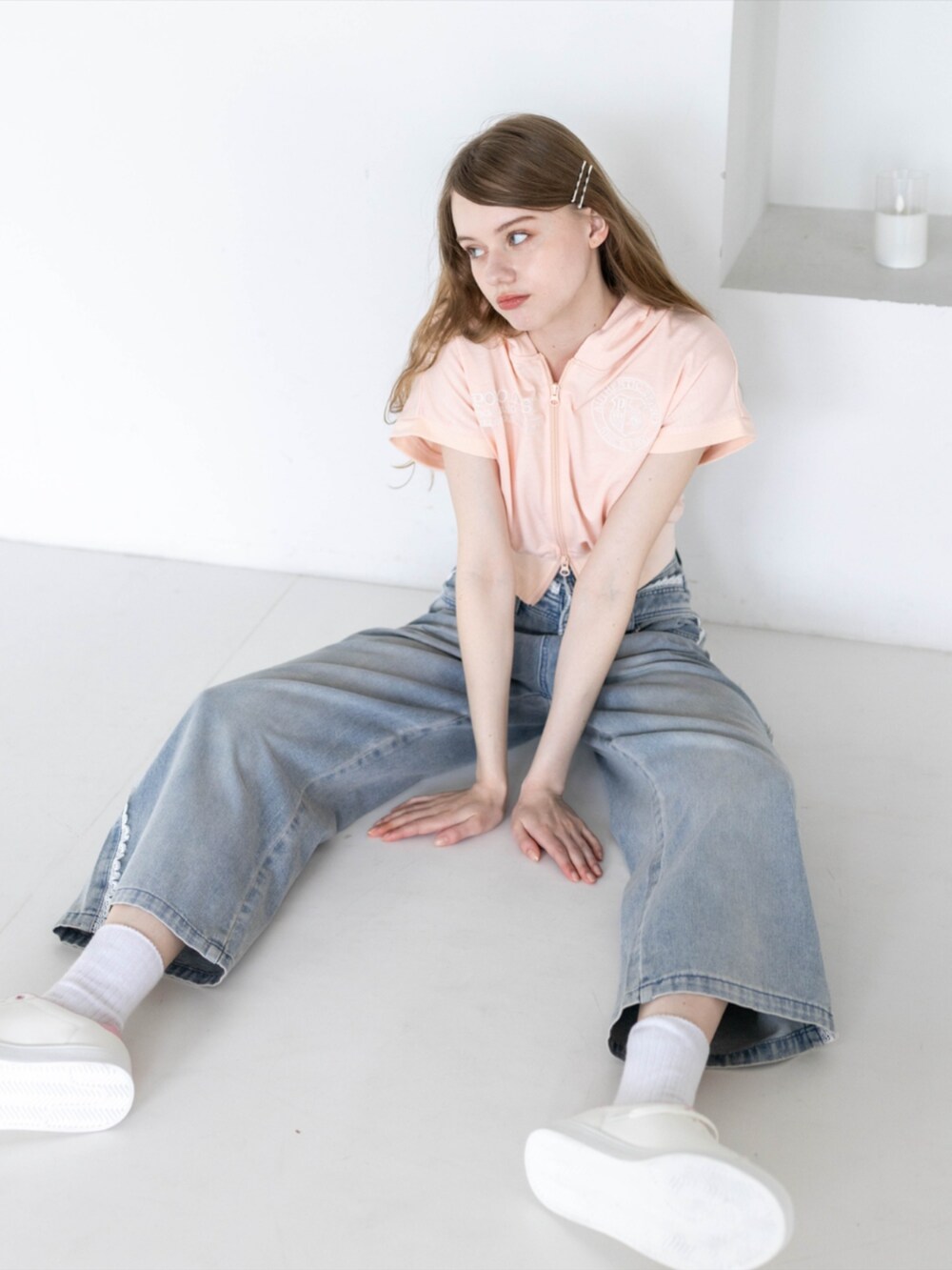 ピンク系のスニーカー、ピンク系のパーカー、ブルー系のデニムパンツを着用したレディースの夏コーディネートの6枚目の写真