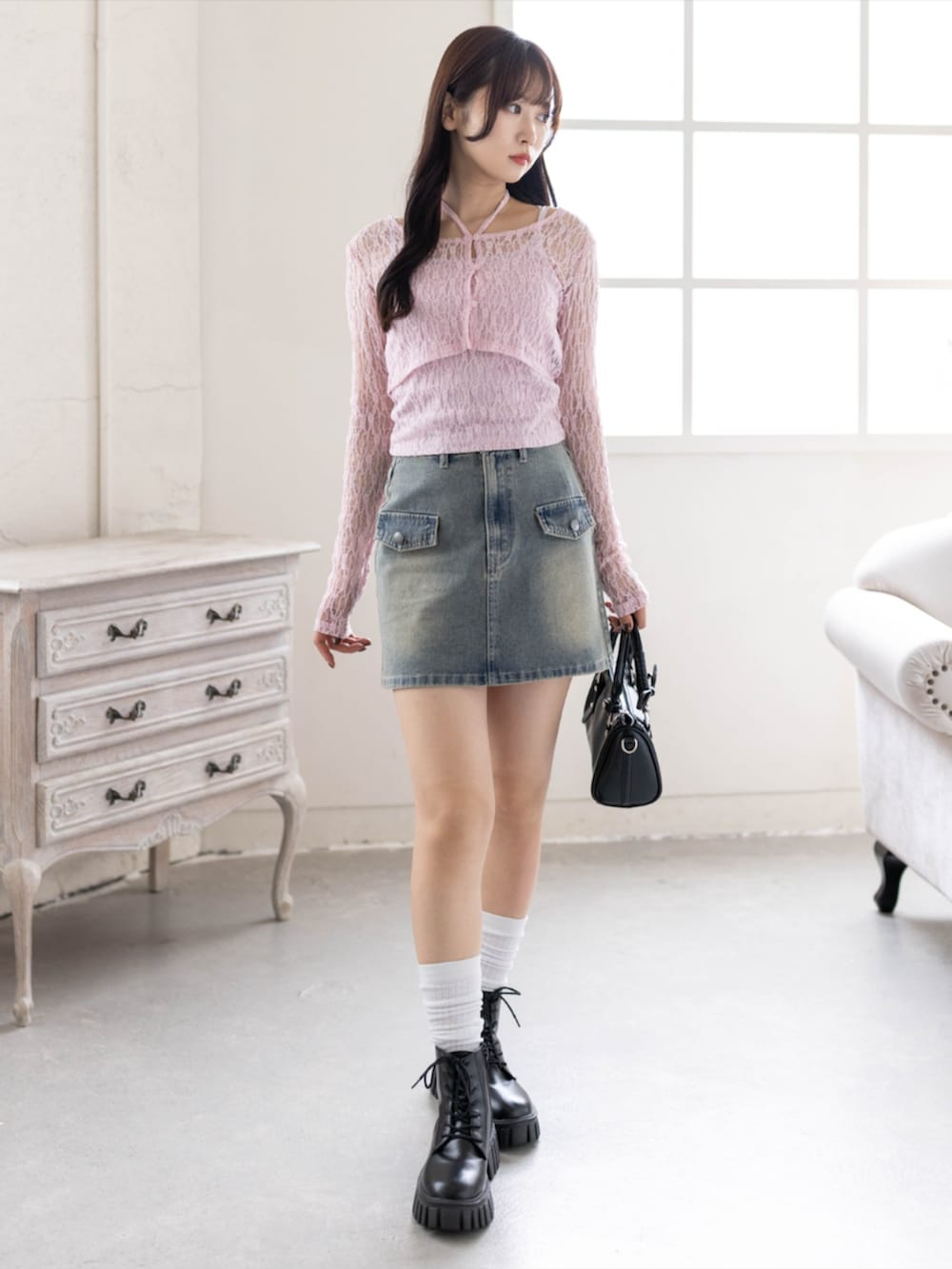 ブラック系のブーツ、ブラック系のハンドバッグ、ピンク系のカーディガン/ボレロを着用したレディースの春コーディネートの2枚目の写真