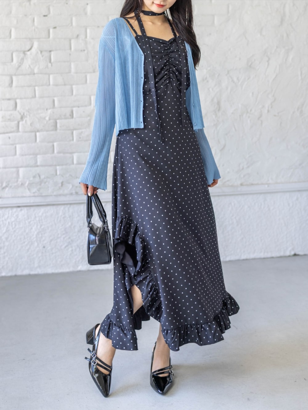 ブラック系のパンプス、グレー系のカーディガン/ボレロ、ブラック系のワンピースを着用したレディースの春コーディネートの2枚目の写真