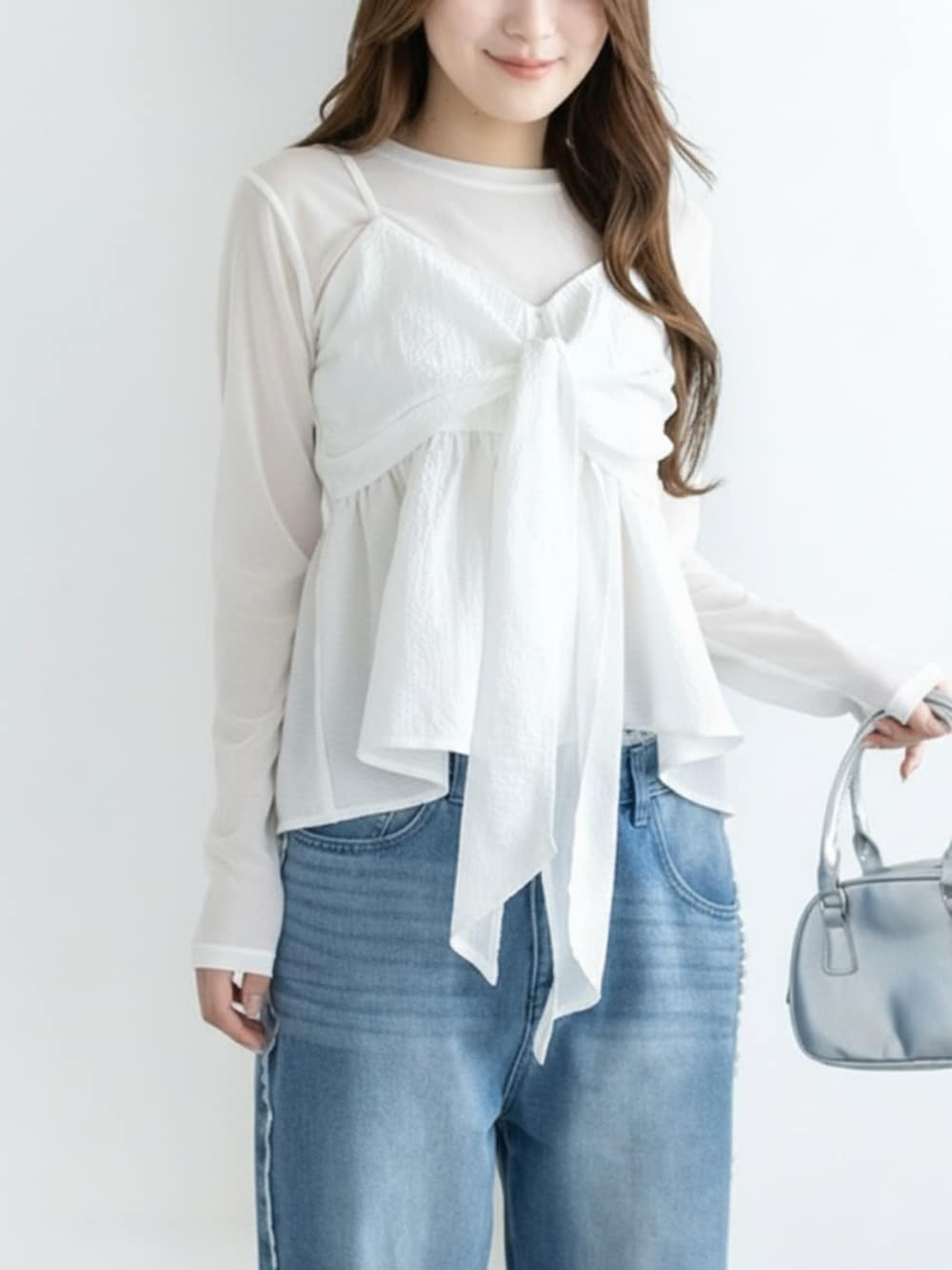 シルバー系のパンプス、ブルー系のデニムパンツ、ホワイト系のキャミソールを着用したレディースの冬コーディネートの3枚目の写真