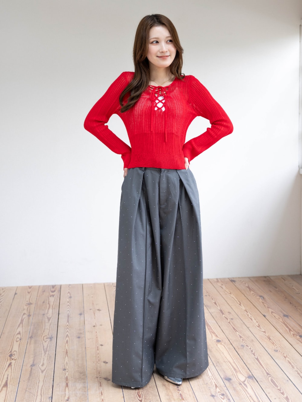 シルバー系のパンプス、レッド系のニット/セーター、グレー系のその他パンツを着用したレディースの春コーディネートの2枚目の写真