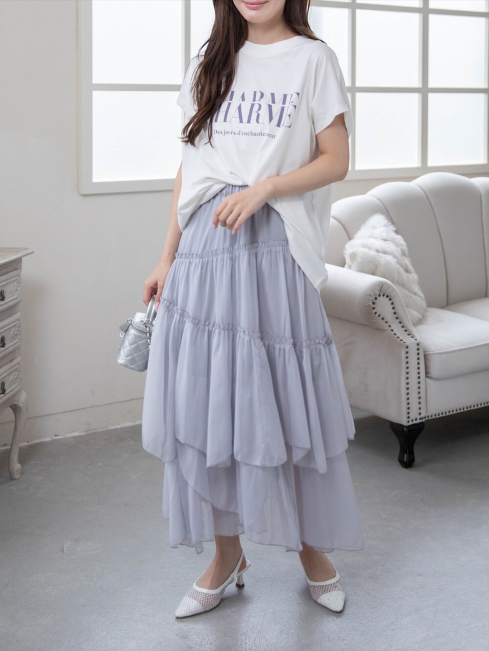 ホワイト系のパンプス、グレー系のスカート、ホワイト系のTシャツ/カットソーを着用したレディースの夏コーディネートの3枚目の写真