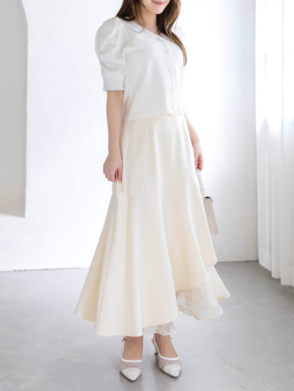 ホワイト系のスカート、ホワイト系のハンドバッグ、ホワイト系のパンプスを着用したレディースの春コーディネートの5枚目の写真