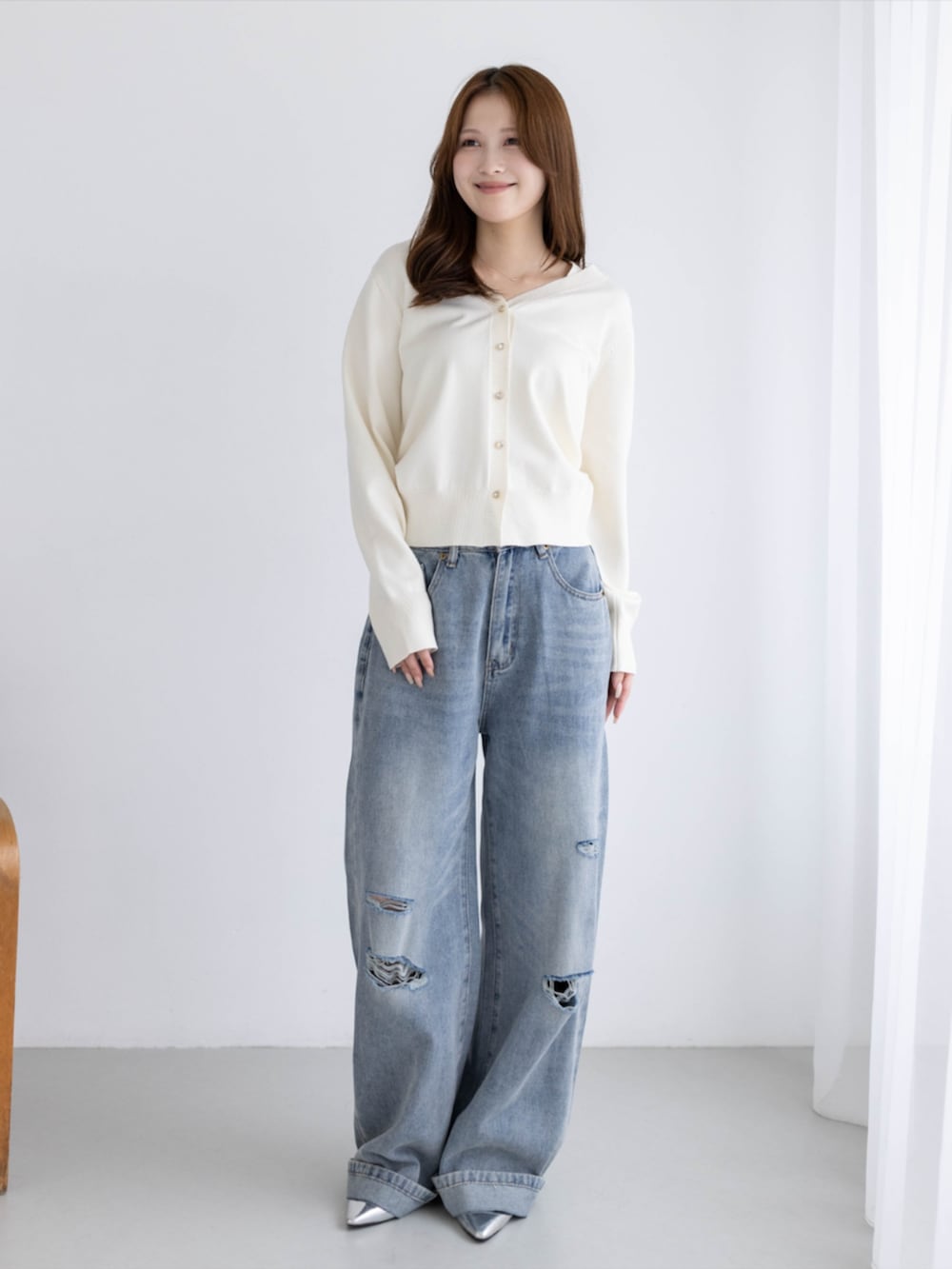 シルバー系のパンプス、ブルー系のデニムパンツ、ホワイト系のカーディガン/ボレロを着用したレディースの秋コーディネートの3枚目の写真