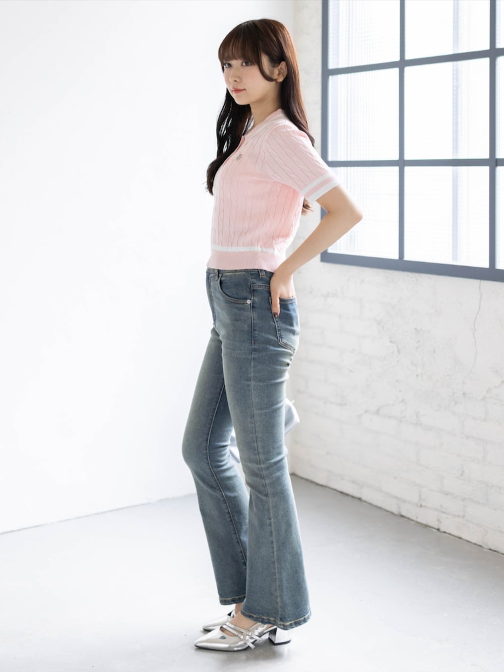 ブルー系のデニムパンツ、シルバー系のパンプス、ピンク系のニット/セーターを着用したレディースの夏コーディネートの2枚目の写真