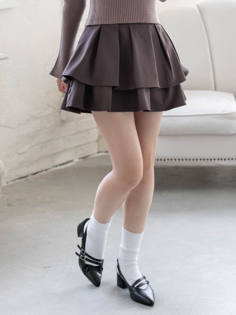 ブラウン系のスカート、ブラック系のパンプス、ブラウン系のニット/セーターを着用したレディースの秋コーディネートの9枚目の写真