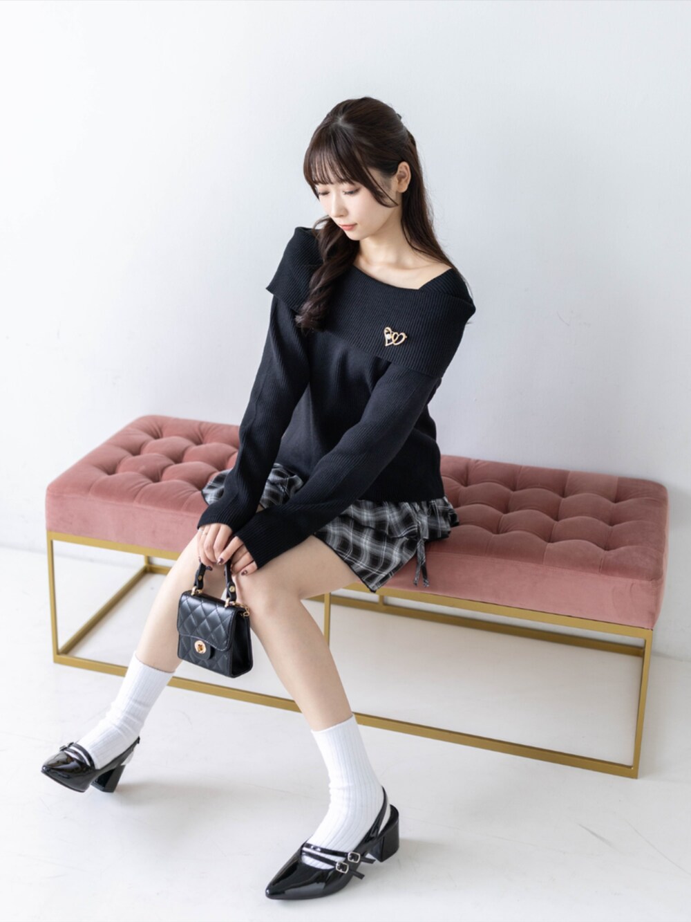 ブラック系のスカート、ブラック系のパンプス、ブラック系のニット/セーターを着用したレディースの秋コーディネートの2枚目の写真