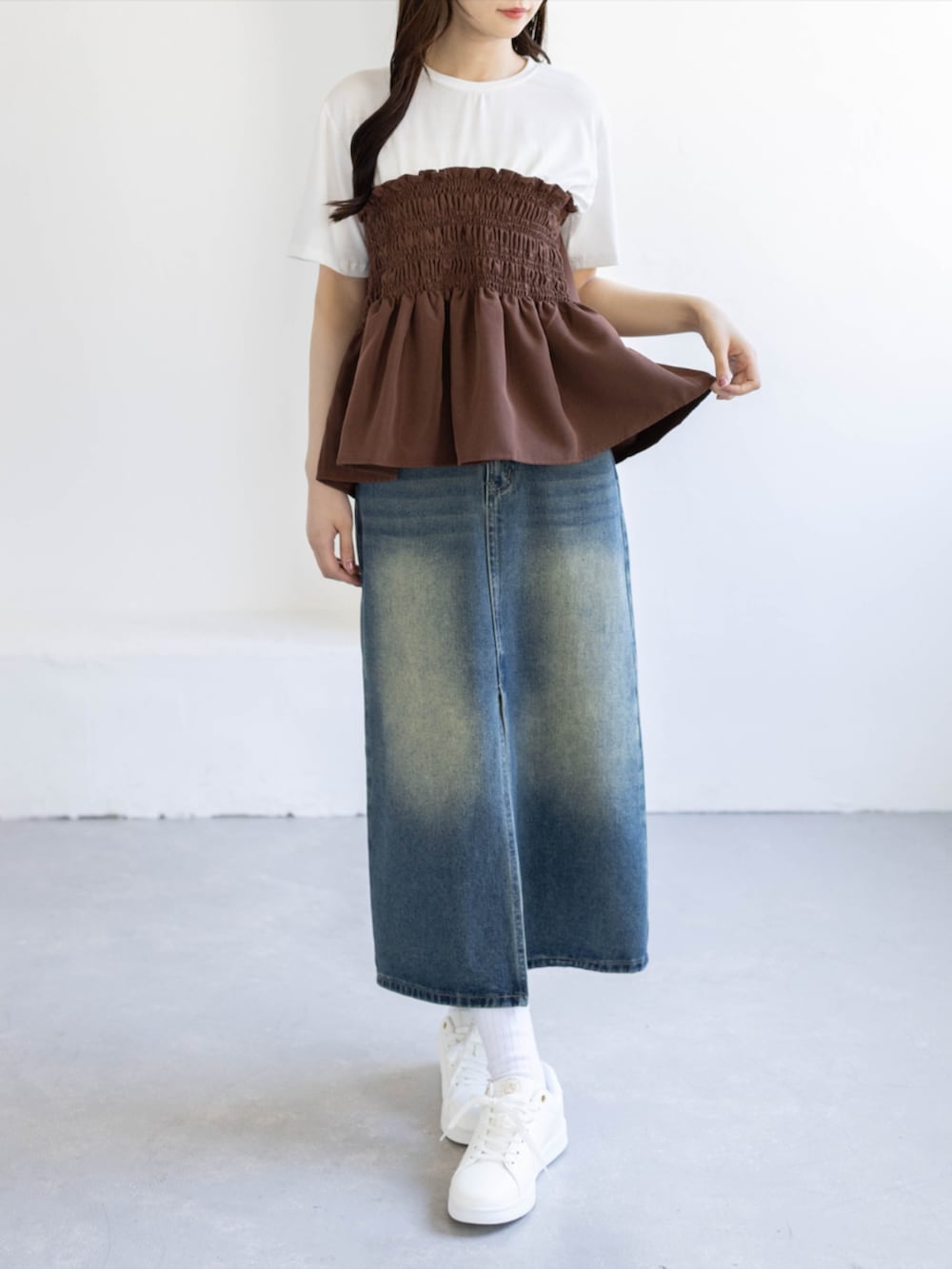 ブルー系のデニムスカート、ゴールド系のスニーカー、ブラウン系のTシャツ/カットソーを着用したレディースの夏コーディネートの4枚目の写真