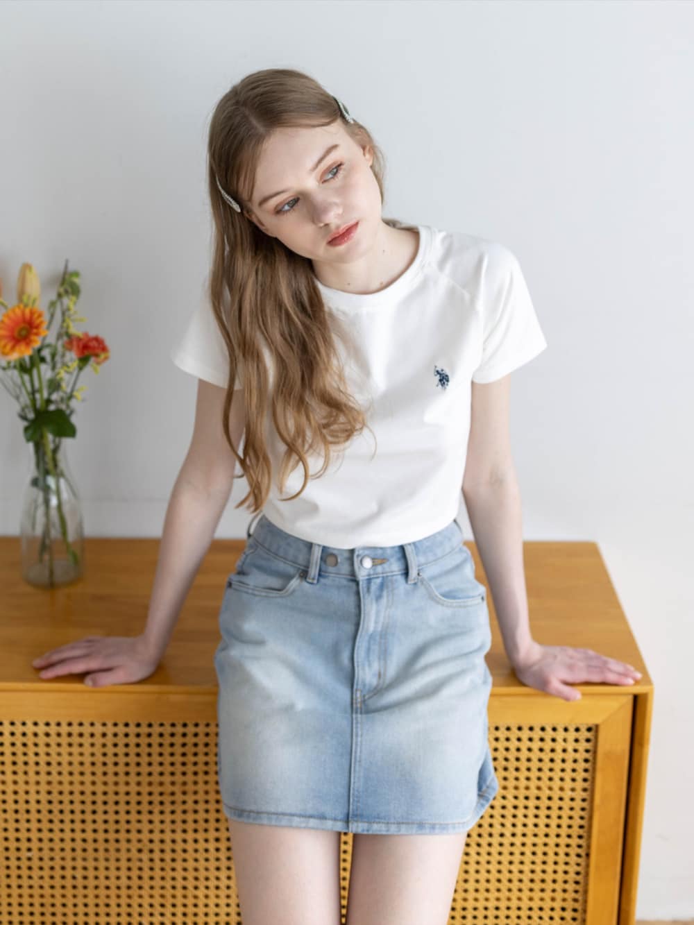 ブルー系のデニムスカート、ホワイト系のTシャツ/カットソーを着用したレディースの夏コーディネートの3枚目の写真