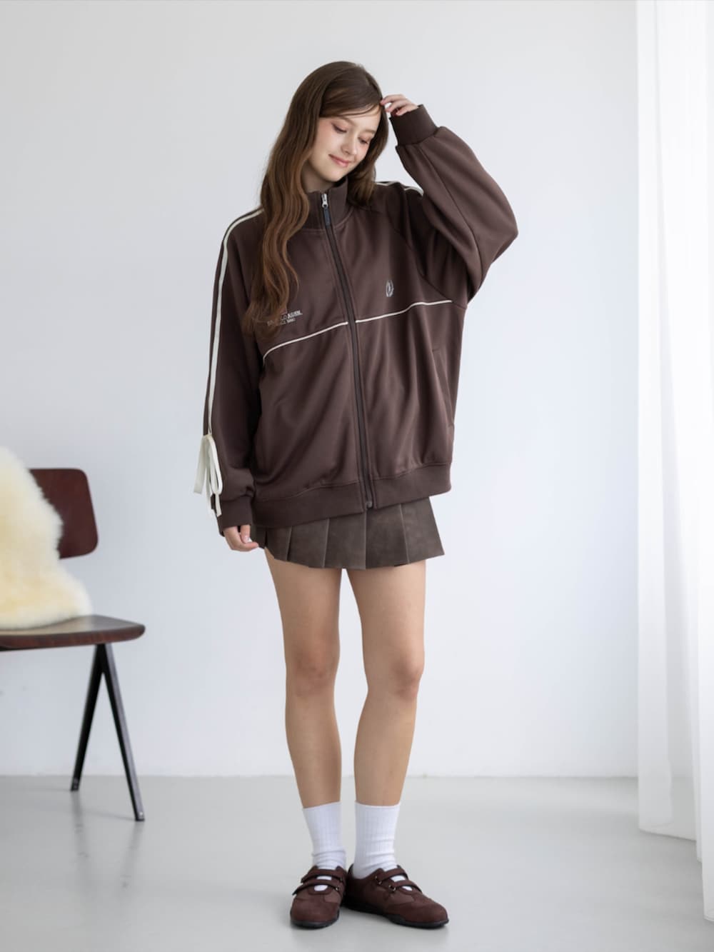ブラウン系のスカート、ブラウン系のTシャツ/カットソー、ブラウン系のスニーカーを着用したレディースの秋コーディネートの5枚目の写真