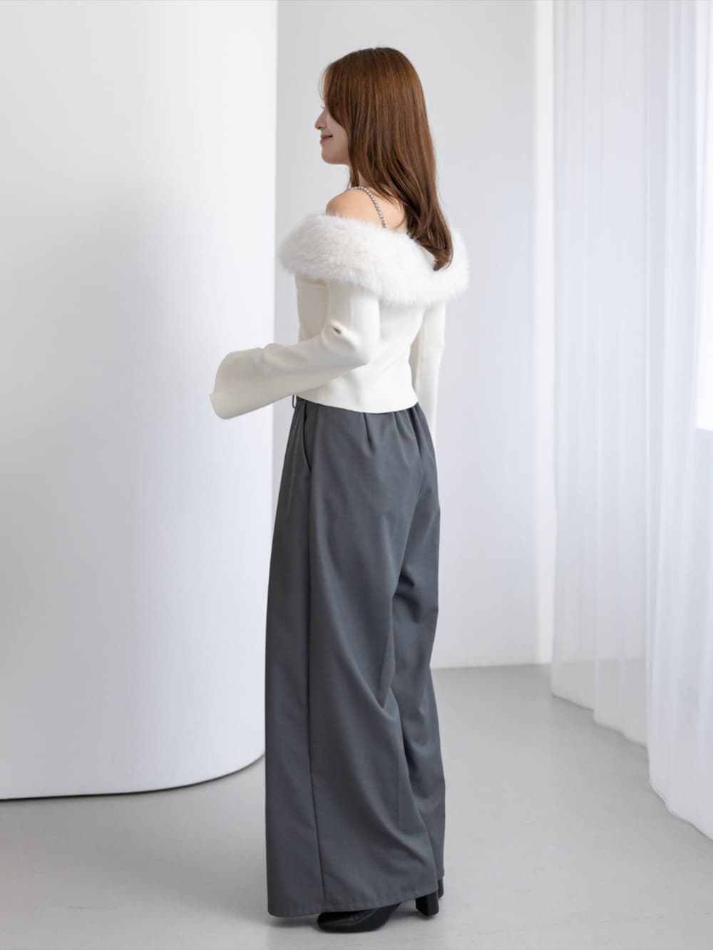 ブラック系のブーツ、グレー系のその他パンツ、ホワイト系のニット/セーターを着用したレディースの秋コーディネートの2枚目の写真