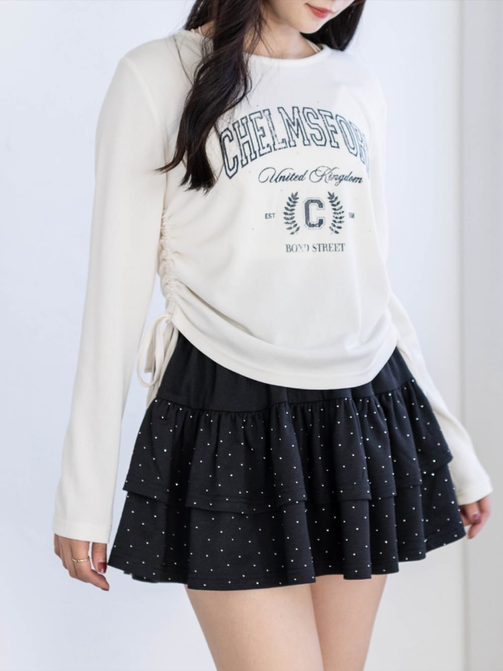 ブラック系のブーツ、ブラック系のスカート、ホワイト系のTシャツ/カットソーを着用したレディースの夏コーディネートの5枚目の写真