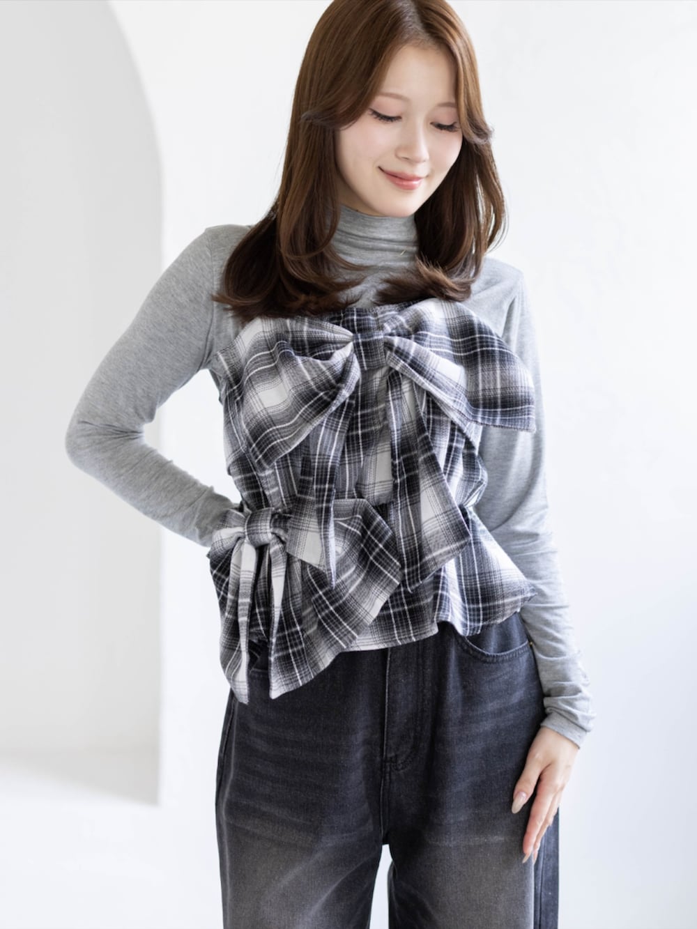 グレー系のTシャツ/カットソー、ブラック系のデニムパンツ、ブラック系のブーツを着用したレディースの秋コーディネートの3枚目の写真