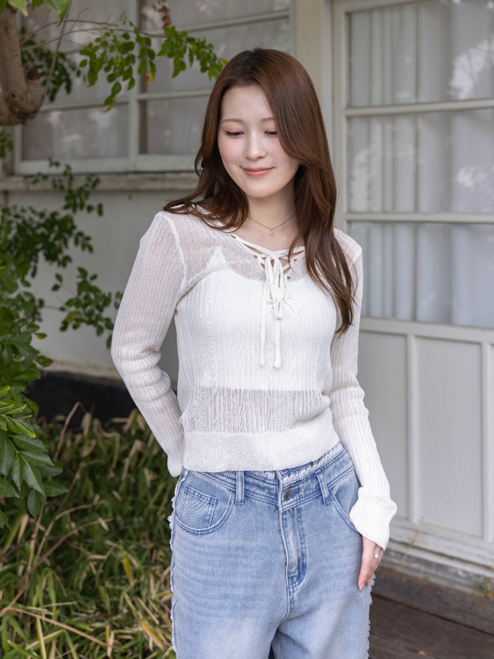 シルバー系のパンプス、ブルー系のデニムパンツ、ホワイト系のニット/セーターを着用したレディースの春コーディネートの4枚目の写真