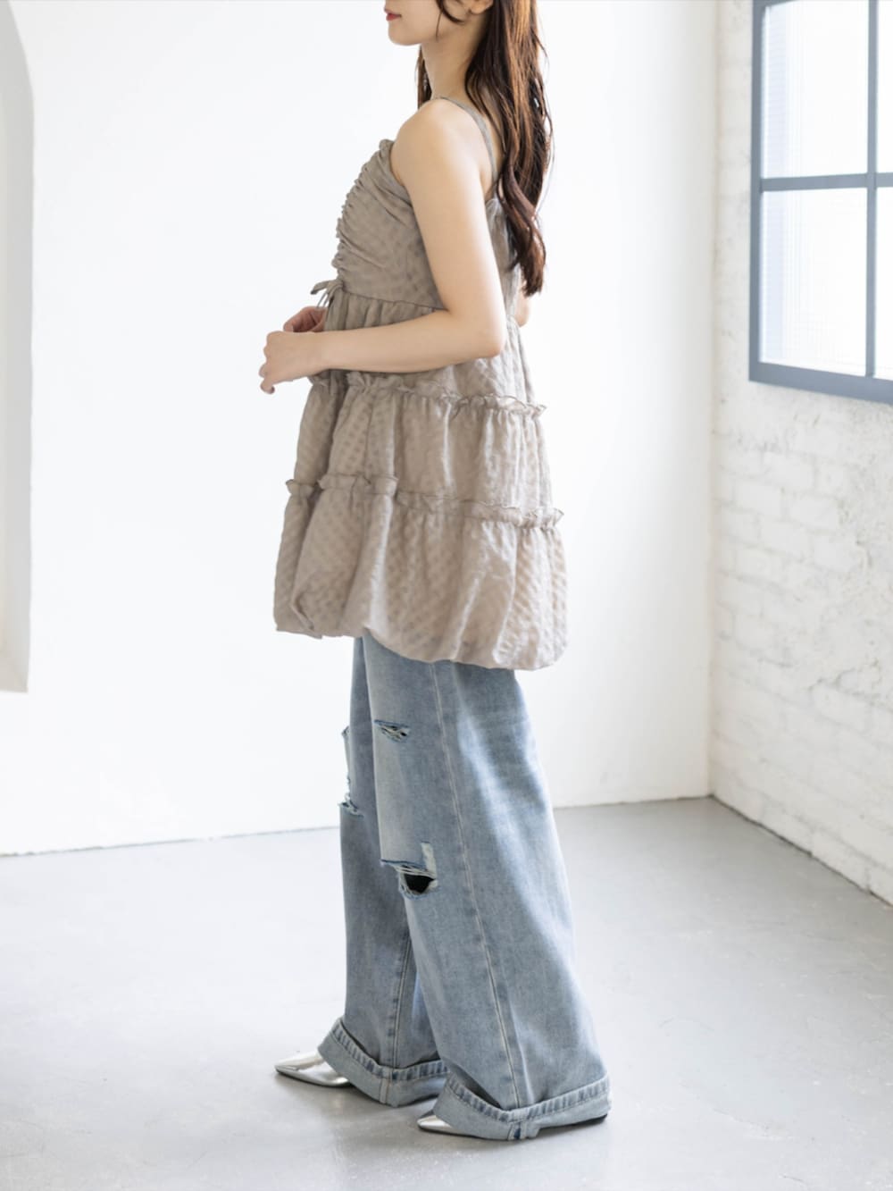 シルバー系のパンプス、ベージュ系のワンピース、ブルー系のデニムパンツを着用したレディースの夏コーディネートの5枚目の写真