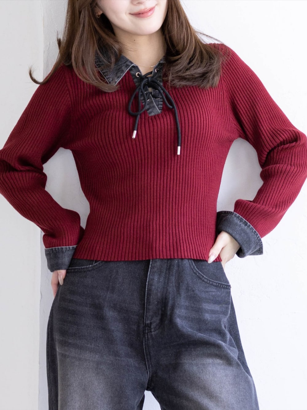 ブラック系のデニムパンツ、ブラック系のブーツ、レッド系のニット/セーターを着用したレディースの秋コーディネートの3枚目の写真