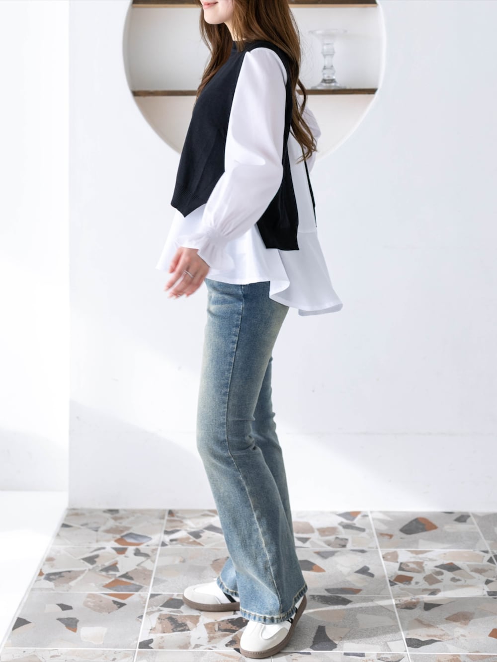 ブルー系のデニムパンツ、ホワイト系のスニーカー、ブラック系のシャツ/ブラウスを着用したレディースの冬コーディネートの4枚目の写真