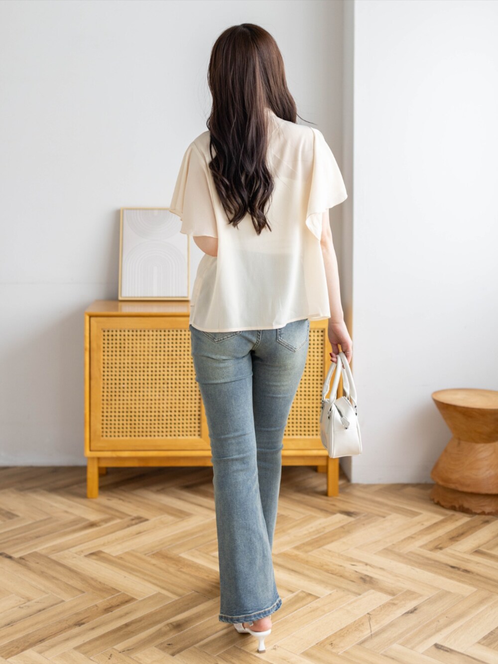 ブルー系のデニムパンツ、ホワイト系のパンプス、イエロー系のシャツ/ブラウスを着用したレディースの夏コーディネートの2枚目の写真