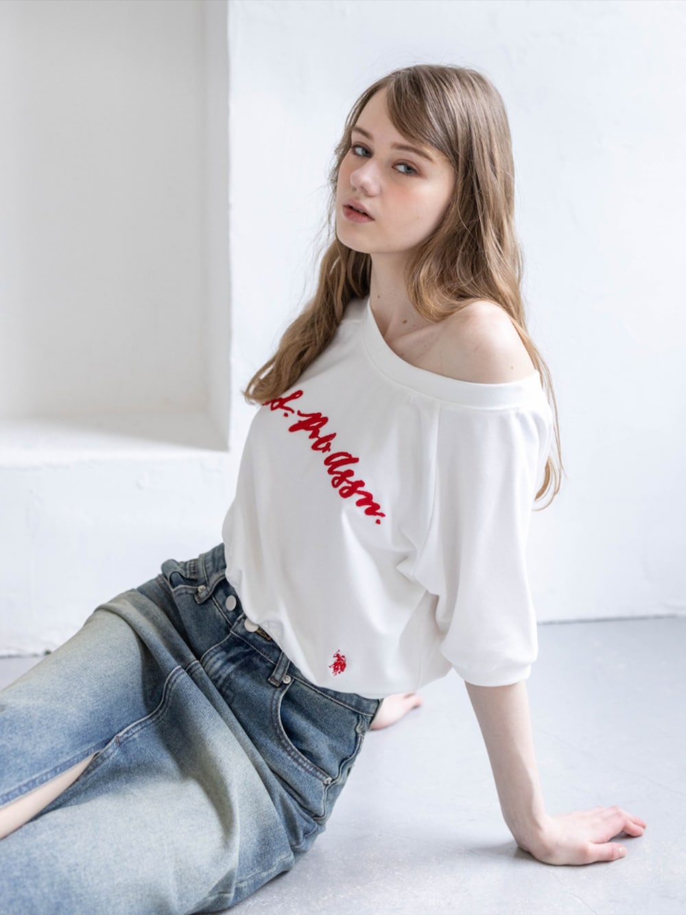 ブラック系のブーツ、ホワイト系のTシャツ/カットソー、ブルー系のデニムスカートを着用したレディースの夏コーディネートの3枚目の写真