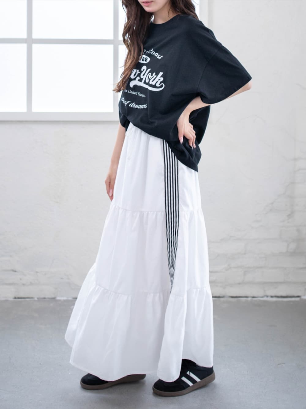ブラック系のスニーカー、ホワイト系のスカート、ブラック系のTシャツ/カットソーを着用したレディースの夏コーディネートの4枚目の写真
