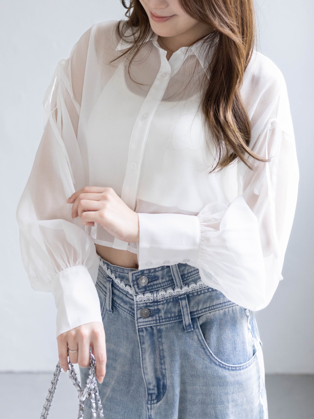 ブルー系のデニムパンツ、ホワイト系のパンプス、ホワイト系のシャツ/ブラウスを着用したレディースの春コーディネートの5枚目の写真