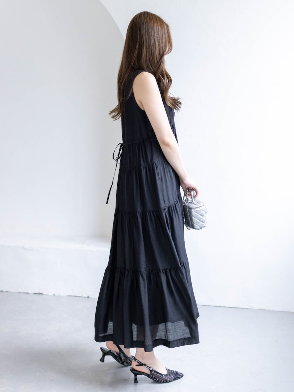 ブラック系のパンプス、ブラック系のワンピースを着用したレディースの春コーディネートの3枚目の写真