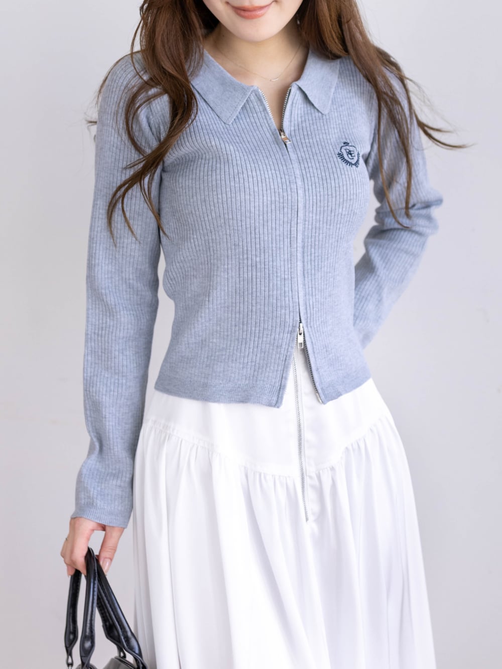 ブラック系のブーツ、グレー系のニット/セーター、ホワイト系のスカートを着用したレディースの冬コーディネートの5枚目の写真